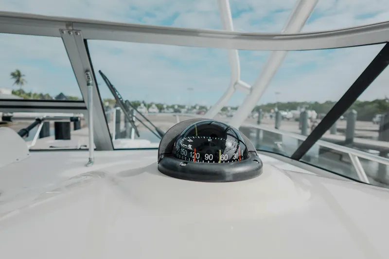 Slide: The Image of Compass on 2007 Boston Whaler 305 Conquest boat, docked with clear sky background. - 31