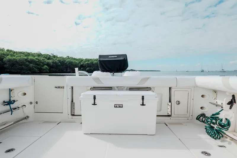 Slide: The Image of 2007 Boston Whaler 305 Conquest deck with Yeti cooler, ocean view, and lush greenery. - 38
