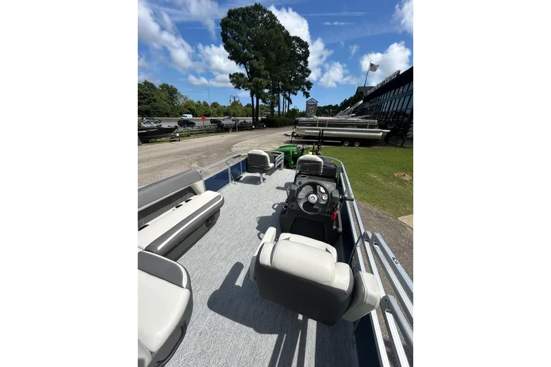 Slide: The Image of 2026 Sun Tracker Bass Buggy 18 DLX pontoon boat interior with seating and steering console. - 5