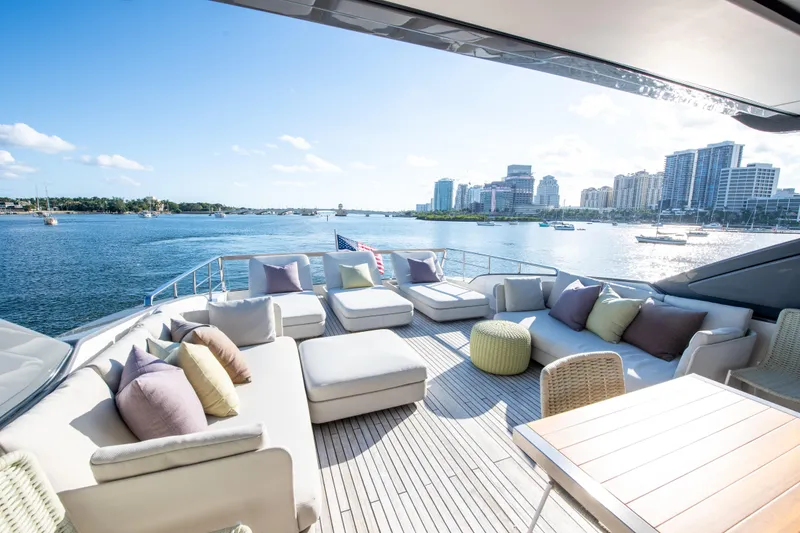 Slide: The Image of Luxurious 2016 Sanlorenzo SL86 yacht deck with plush seating, overlooking a scenic waterfront cityscape. - 10