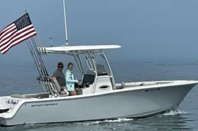 The Image of 2021 Sportsman Open 242 Center Console boat with American flag on calm water. - 0