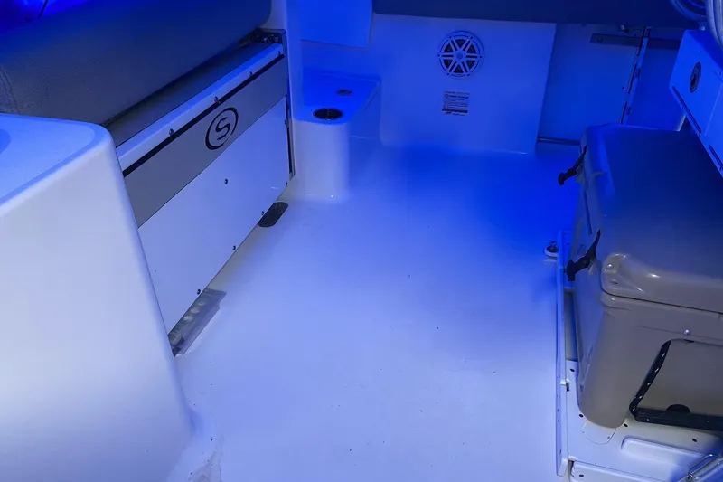 Slide: The Image of 2021 Sportsman Open 242 Center Console interior with blue lighting and seating area. - 18