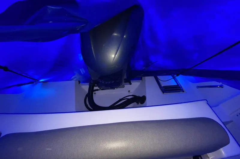 Slide: The Image of 2021 Sportsman Open 242 Center Console boat under blue tarp with visible engine. - 26