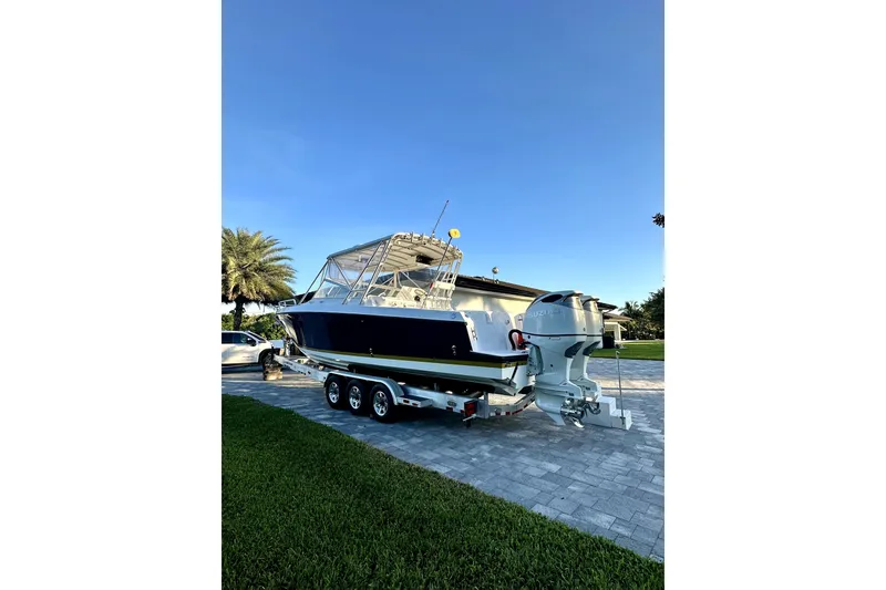 Slide: The Image of 2006 Contender 35 Express Side Console boat on trailer, parked in driveway. - 25