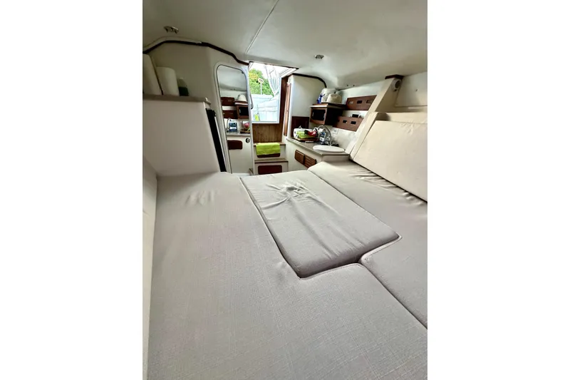 Slide: The Image of 2006 Contender 35 Express Side Console cabin interior with cozy seating and storage. - 4