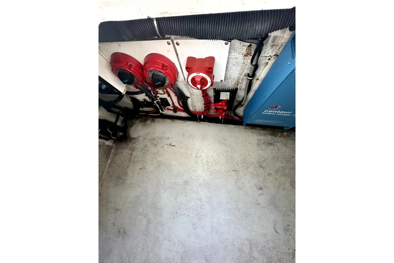 Slide: The Image of 2006 Contender 35 Express Side Console engine compartment with red switches and wiring. - 6