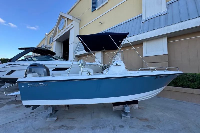 The Image of 2023 Edgewater 188CC boat with blue hull and canopy, displayed outdoors. - 0