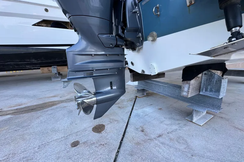 Slide: The Image of 2023 Edgewater 188CC boat engine on a stand, showcasing propeller and lower unit. - 19