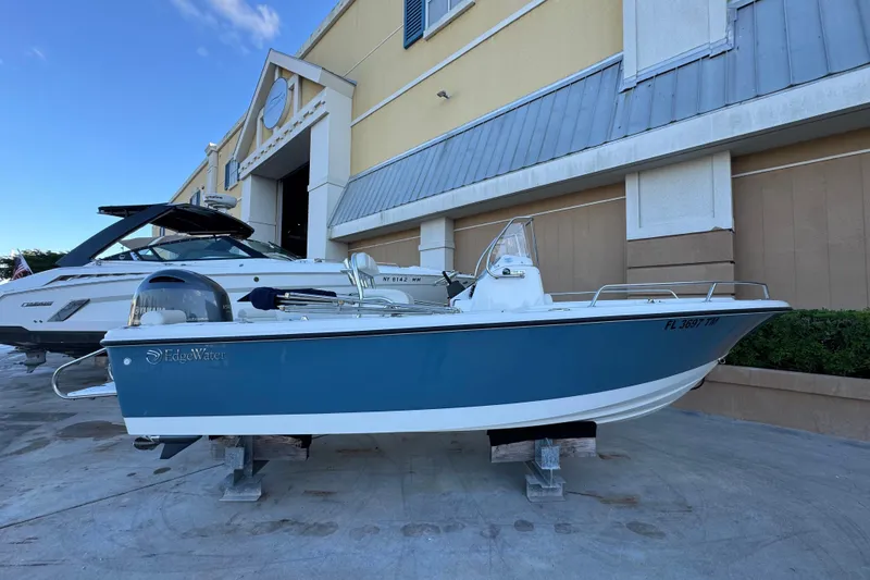 Slide: The Image of 2023 Edgewater 188CC boat displayed outside a building, showcasing sleek design and blue hull. - 4