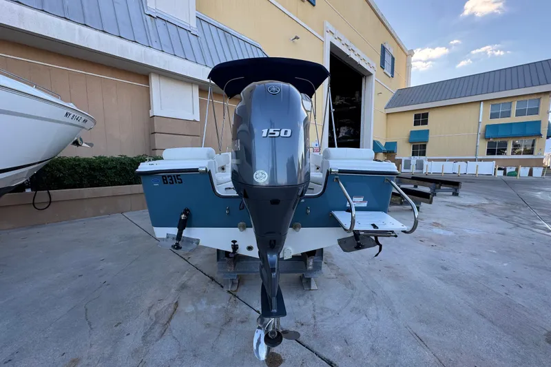 Slide: The Image of 2023 Edgewater 188CC boat with Yamaha 150 engine, parked outside a building. - 5