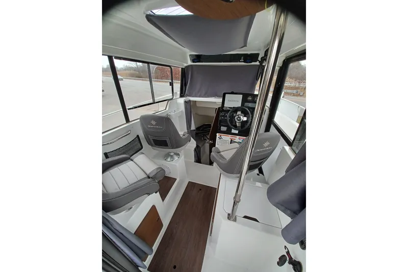 Slide: The Image of Interior of 2022 Jeanneau NC 695 Sport Serie 2 boat, featuring modern seating and navigation equipment. - 6