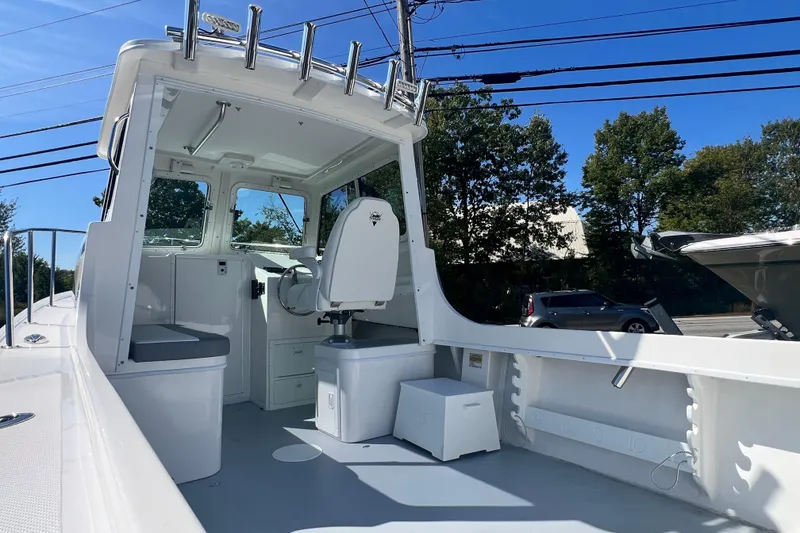 Slide: The Image of 2026 Steiger Craft 23 DV Miami boat interior with helm and seating, under clear blue sky. - 5