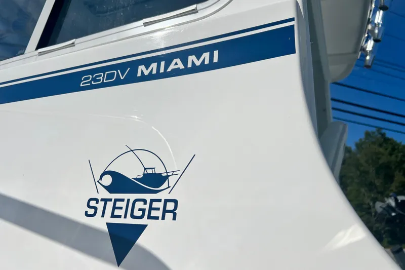 Slide: The Image of 2026 Steiger Craft 23 DV Miami boat logo and model name on white hull. - 6