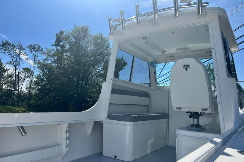 Slide: The Image of 2026 Steiger Craft 23 DV Miami boat interior with seating and helm, under clear blue sky. - 8