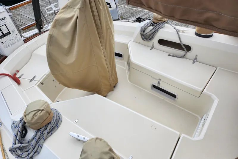 Slide: The Image of 1988 Sabre 42 sailboat cockpit with covered equipment and neatly coiled ropes. - 13