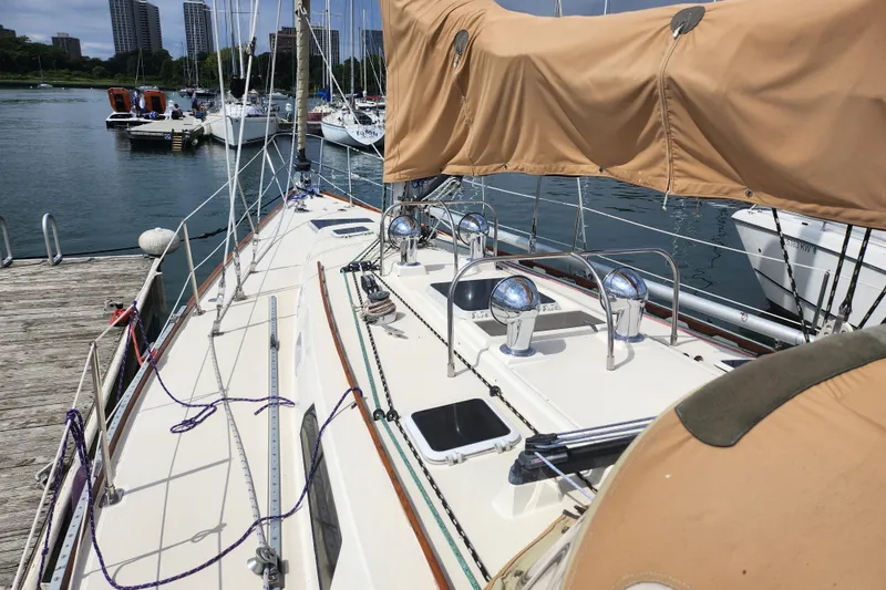 Slide: The Image of 1988 Sabre 42 sailboat docked at marina, featuring covered deck and polished fittings. - 16
