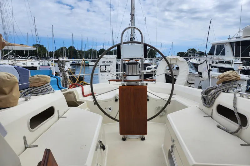Slide: The Image of 1988 Sabre 42 sailboat cockpit with steering wheel, docked in marina. - 17