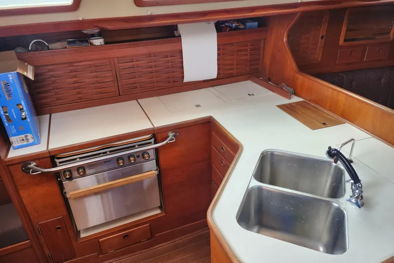 Slide: The Image of 1988 Sabre 42 yacht kitchen with dual sink, stove, and wooden cabinetry. - 23