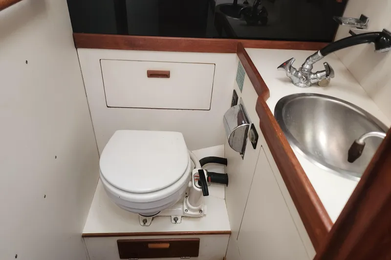Slide: The Image of 1988 Sabre 42 yacht bathroom with toilet, sink, and wooden accents. - 30