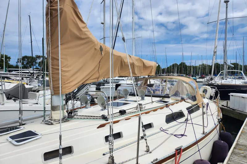 Slide: The Image of 1988 Sabre 42 sailboat docked in a marina, featuring tan sail cover. - 5