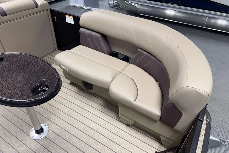 Slide: The Image of 2026 Sylvan Mirage 8520 Party Fish boat interior with beige seating and round table. - 17