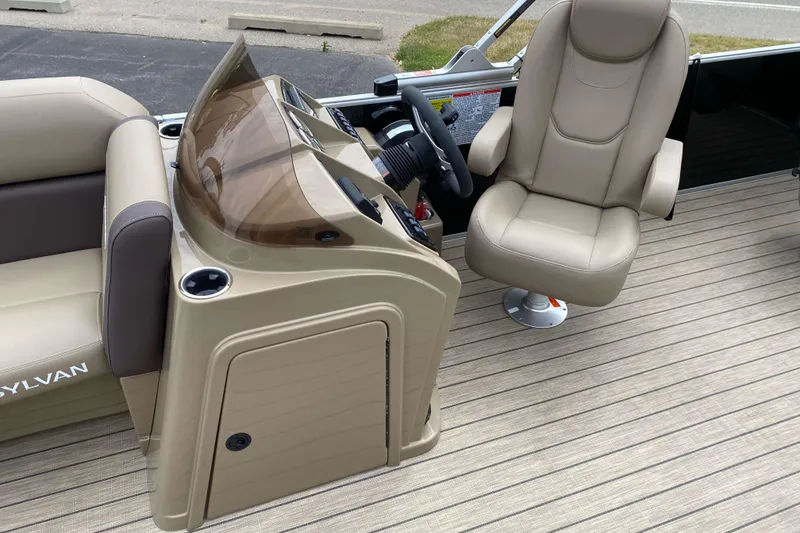 Slide: The Image of 2026 Sylvan Mirage 8520 Party Fish boat interior with beige captain's chair and console. - 8
