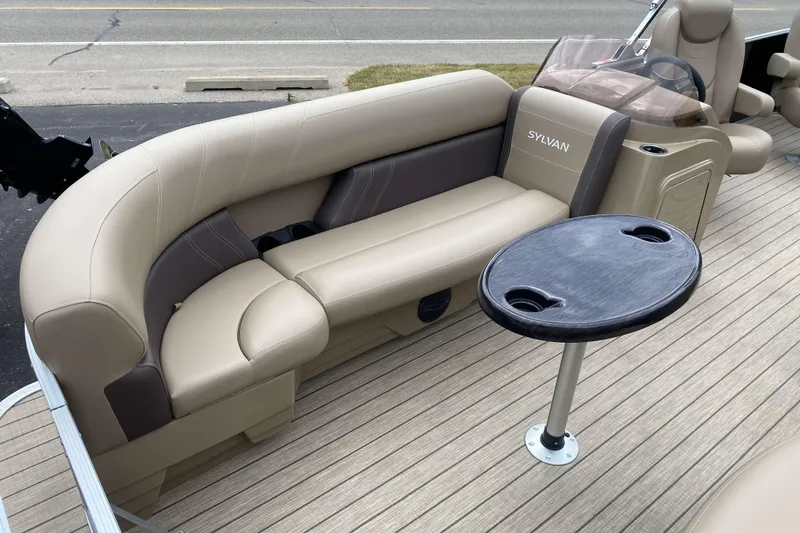 Slide: The Image of 2026 Sylvan Mirage Fish 8520 Party Fish boat interior with beige seating and table. - 4