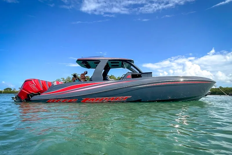 Slide: The Image of 2022 Deep Impact 399 Sport boat on water, featuring sleek design and vibrant red accents. - 20