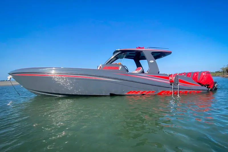 Slide: The Image of 2022 Deep Impact 399 Sport boat on water, sleek gray design with red accents. - 21