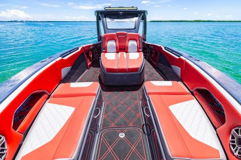 Slide: The Image of 2022 Deep Impact 399 Sport boat with red and white seating on clear blue water. - 25
