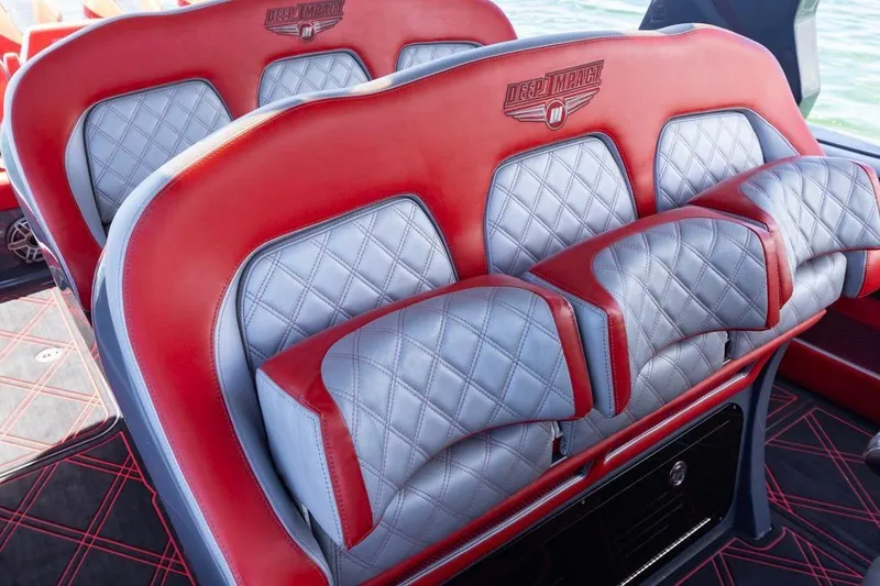 Slide: The Image of Luxury seating in 2022 Deep Impact 399 Sport boat, featuring red and gray quilted upholstery. - 30