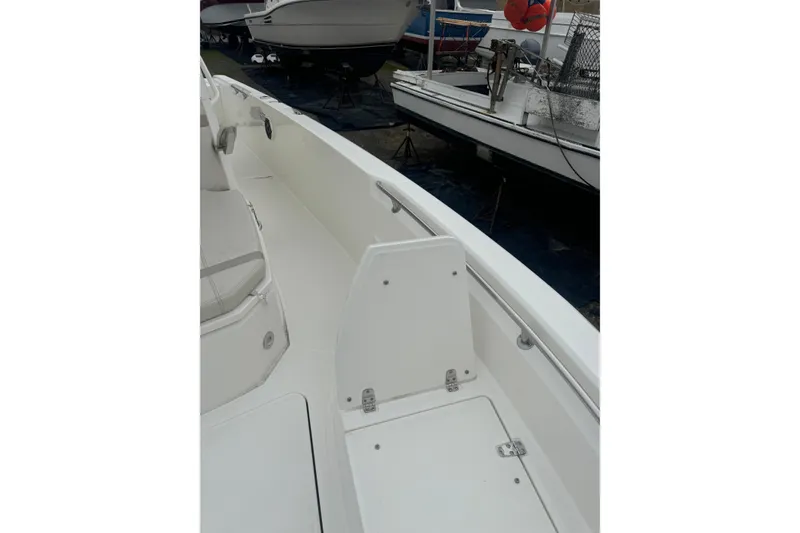 Slide: The Image of 2023 Boston Whaler 280 Dauntless boat interior with white seating and cup holders. - 13