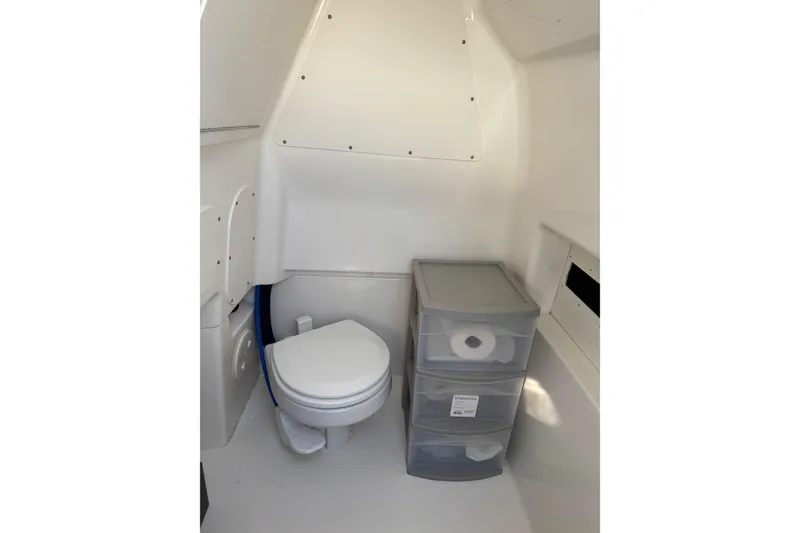 Slide: The Image of Interior of 2023 Boston Whaler 280 Dauntless boat bathroom with toilet and storage. - 17