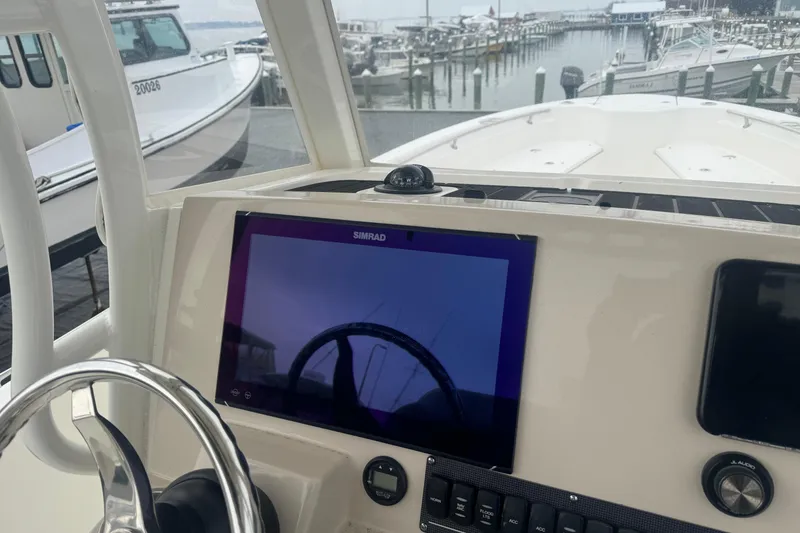 Slide: The Image of 2023 Boston Whaler 280 Dauntless helm with steering wheel and navigation controls. - 8