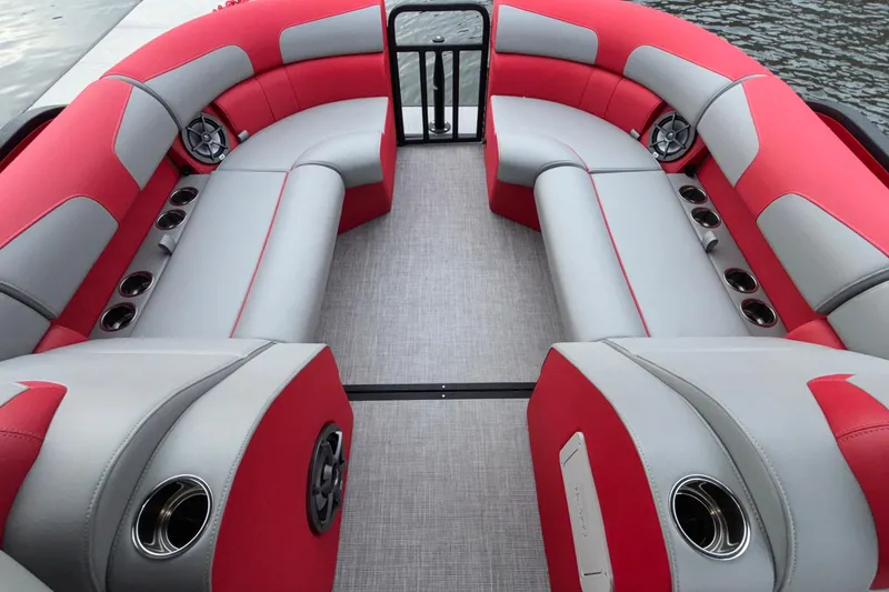 Slide: The Image of 2025 Montara 25 Surf Boss boat interior with red and gray seating, cup holders, and speakers. - 30