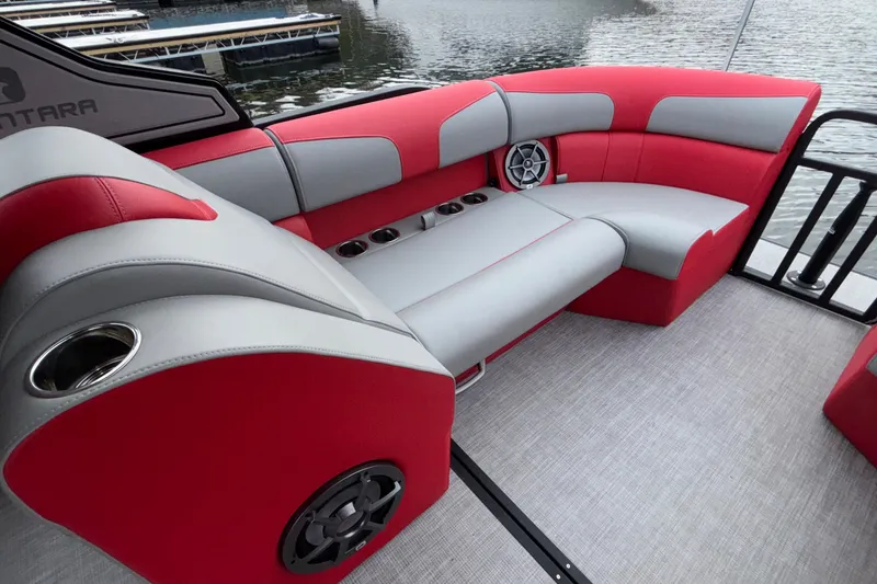 Slide: The Image of 2025 Montara 25 Surf Boss boat interior with red and gray seating, cup holders, and speaker. - 31