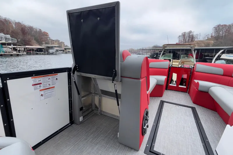 Slide: The Image of 2025 Montara 25 Surf Boss boat interior with red and gray seating, docked by the lake. - 40