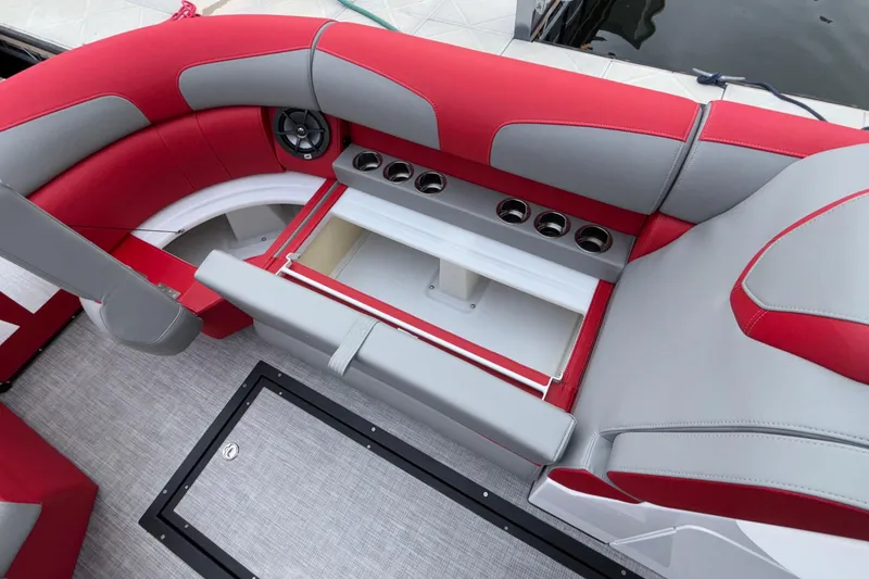 Slide: The Image of 2025 Montara 25 Surf Boss boat interior with red and gray seating, cup holders, and storage. - 41