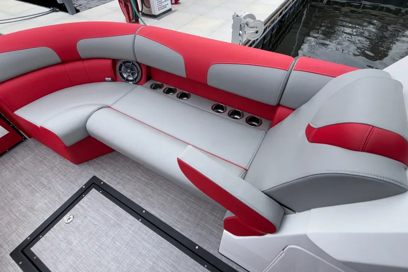 Slide: The Image of 2025 Montara 25 Surf Boss boat interior with red and gray seating, cup holders, and speaker. - 43