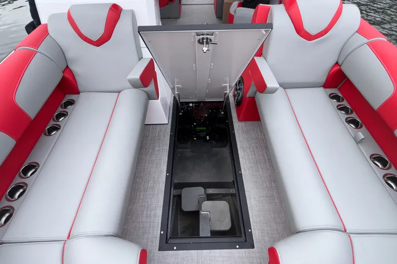 Slide: The Image of 2025 Montara 25 Surf Boss interior with red and gray seating, open storage compartment. - 44