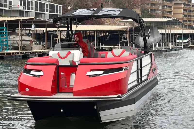 Slide: The Image of 2025 Montara 25 Surf Boss boat in water, featuring red and gray seating, docked at marina. - 60