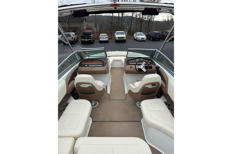 Slide: The Image of 2009 Cobalt 242 boat interior with beige and white seating, dashboard, and steering wheel. - 8