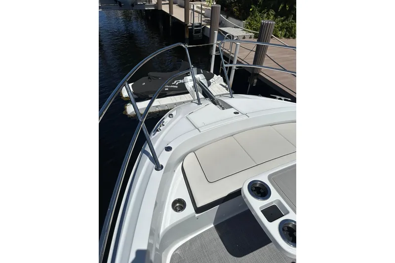 Slide: The Image of 2022 Jeanneau Leader 12.5 WA boat deck with seating and railing, docked by water. - 11