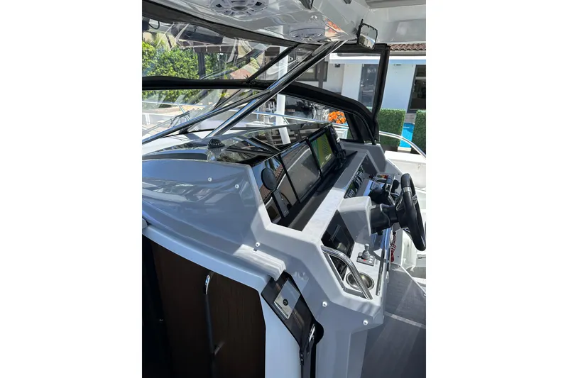 Slide: The Image of 2022 Jeanneau Leader 12.5 WA helm with modern navigation equipment and steering wheel. - 15