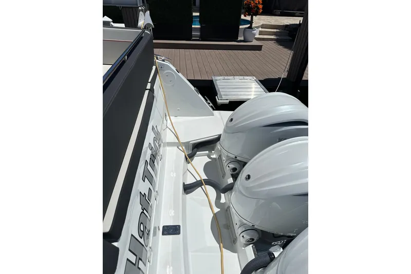Slide: The Image of 2022 Jeanneau Leader 12.5 WA boat with dual outboard engines, docked on a sunny day. - 22