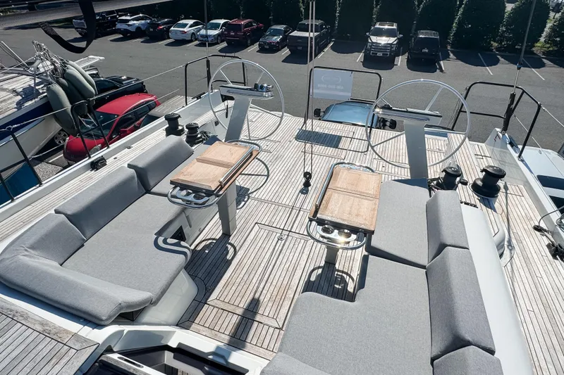 Slide: The Image of 2024 Beneteau First 53 yacht deck with dual steering wheels and cushioned seating. - 13