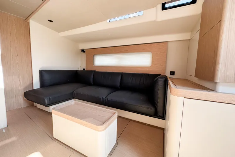 Slide: The Image of Luxurious interior of 2024 Beneteau First 53 yacht with modern black sofa and wooden accents. - 15
