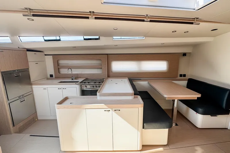 Slide: The Image of Luxurious interior of 2024 Beneteau First 53 yacht, featuring modern kitchen and dining area. - 19