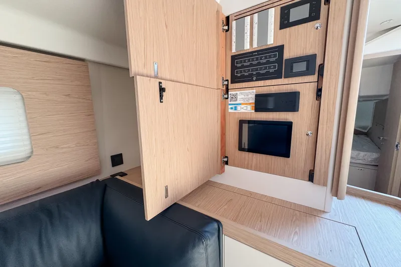Slide: The Image of 2024 Beneteau First 53 yacht interior with control panel and wooden cabinetry. - 25