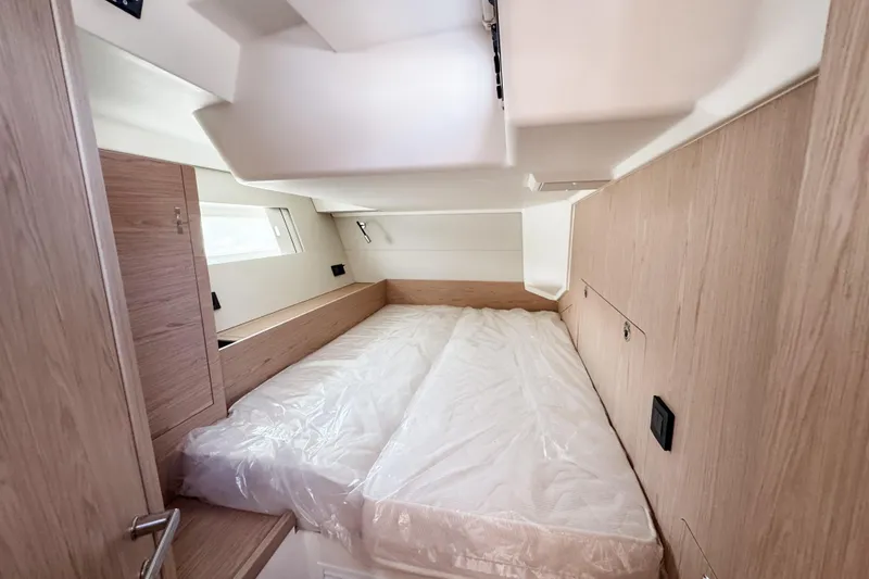 Slide: The Image of 2024 Beneteau First 53 cabin interior with modern wood finish and cozy bed. - 29